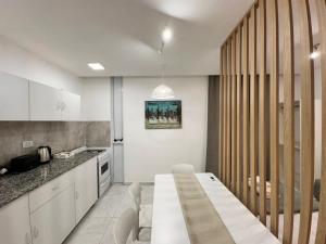 a kitchen with a white table in a room at Vela Villa Apart in Villa Ángela