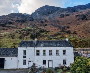 een wit huis voor een berg bij The Cottage in Borrowdale Valley