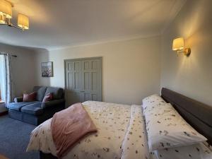 een slaapkamer met een bed en een bank bij The Cottage in Borrowdale Valley
