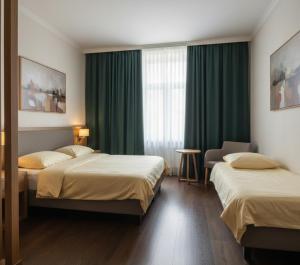 two beds in a hotel room with green curtains at Özlem Apart&Pansiyon in Hatay +16 photos