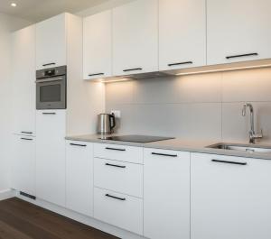 a white kitchen with white cabinets and a sink at Özlem Apart&Pansiyon in Hatay