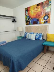 a bedroom with a blue bed and a chair at Habitación privada en casa de huespedes in Guadalajara