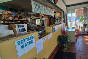 Un restaurante con un mostrador con un cartel de agua embotellada. en Arrow Motel by OYO Near Downtown, en Orlando