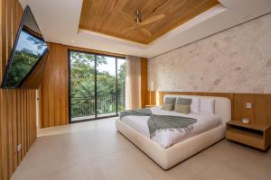 ein Schlafzimmer mit einem weißen Bett und einem großen Fenster in der Unterkunft Hacienda Pinilla Vacation Rentals in Tamarindo