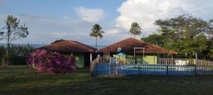 a house with a blue fence in front of a pool at Pousada e Restaurante Cajutuba in Belterra