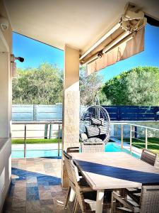 a patio with a table and chairs and a large window at Villa Lenuska in Quartu SantʼElena