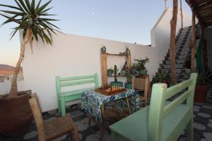 a room with a table and chairs and a table and a plant at Agadir Funky Chill Guesthouse Surf, Horse, Music adventures in Aourir