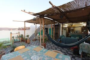 a patio with a hammock and a table and chairs at Agadir Funky Chill Guesthouse Surf, Horse, Music adventures in Aourir