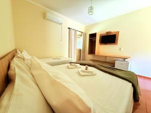 une chambre avec un lit avec deux serviettes dessus dans l'établissement Montinni Pousada, à Socorro