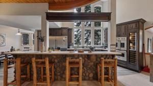 an open kitchen with a large island with stools at Sparrow by AvantStay Modern Mountain Retreat w Hot Tub Pool Table Games in Truckee
