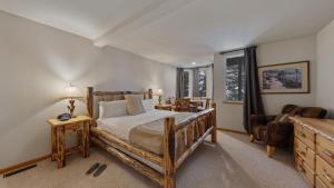 a bedroom with a wooden bed and a couch at Sparrow by AvantStay Modern Mountain Retreat w Hot Tub Pool Table Games in Truckee