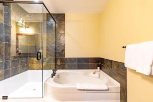 a bathroom with a tub and a glass shower at Spring Creek Serenity at Rundle Cliffs Lodge in Canmore +69 photos