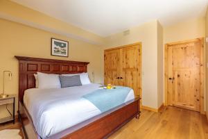 a bedroom with a bed and two wooden doors at Spring Creek Serenity at Rundle Cliffs Lodge in Canmore