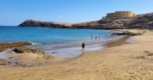 een groep mensen die op het strand lopen bij K'Laya Life Beach A in Arinaga