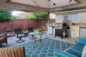 a backyard patio with a table and a kitchen at Family Home with Hot Tub! 2 Mi to Dtwn Riverside in Rubidoux