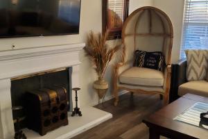 a living room with a fireplace and a chair at Family Home with Hot Tub! 2 Mi to Dtwn Riverside in Rubidoux