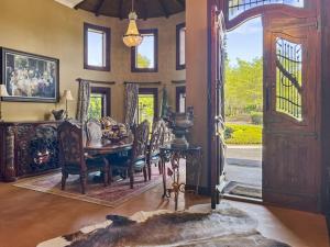 a dining room with a table and chairs and an open door at Le Chateau Moderne - Cedar Barrel Sauna & Spa in Tamahere