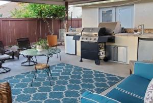 a patio with a table and a stove and a kitchen at Family Home with Hot Tub! 2 Mi to Dtwn Riverside in Rubidoux +16 photos