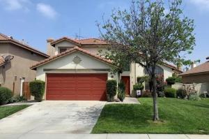 a house with a red garage in a yard at Family Home with Hot Tub! 2 Mi to Dtwn Riverside in Rubidoux