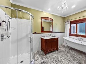 a bathroom with a tub and a sink and a shower at Le Chateau Moderne - Cedar Barrel Sauna & Spa in Tamahere +51 photos