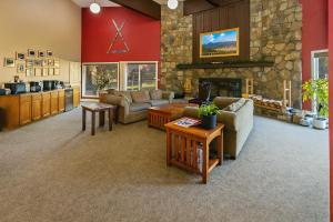 a living room with couches and a stone fireplace at The Bears Den in Red Lodge