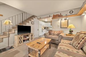 a living room with a couch and a tv at Gunslinger Gateway Red Lodge in Red Lodge