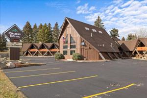 a large wooden building with a sign in a parking lot at Gunslinger Gateway Red Lodge in Red Lodge
