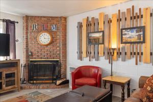 a living room with a fireplace and a clock on the wall at Winchester Way Red Lodge in Red Lodge