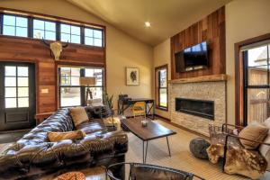 a living room with a leather couch and a fireplace at Montana Mountain Escape in Red Lodge