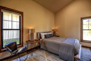 a bedroom with a bed and a chair and two windows at Montana Mountain Escape in Red Lodge +85 photos