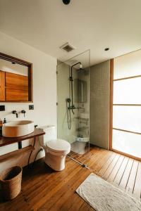 ein Badezimmer mit Toilette, Waschbecken und Dusche in der Unterkunft Villa Beruang in Uluwatu