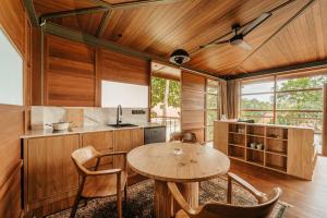eine Küche mit Holzdecke und einem Tisch und Stühlen in der Unterkunft Villa Beruang in Uluwatu