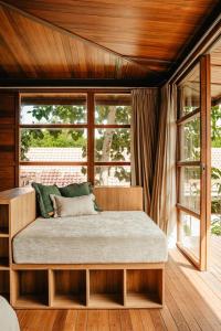 ein großes Bett in einem Zimmer mit Fenstern in der Unterkunft Villa Beruang in Uluwatu