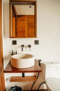 ein Badezimmer mit Waschbecken und Spiegel in der Unterkunft Villa Beruang in Uluwatu + 14 Fotos