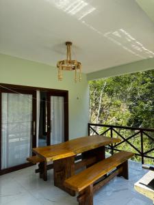 a wooden table on a patio with a chandelier at Casa Aconchego da Serra - Pacoti in Pacoti +11 photos