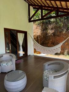 une pièce avec deux fauteuils en osier et un hamac dans l'établissement Casa Aconchego da Serra - Pacoti, à Pacoti