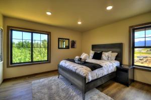 a bedroom with a bed and two windows at Summit Sky Retreat Red Lodge in Red Lodge +80 photos
