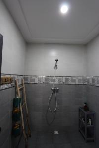 a bathroom with a shower with a shower head at Agadir Funky Chill Guesthouse Surf, Horse, Music adventures in Aourir