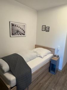 a small bed in a room with white walls at Waldhotel Süllhof in Steyerberg
