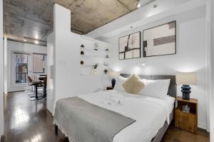 Un dormitorio blanco con una cama grande y un escritorio. en Flat at the Foot of the Mountain With Parking, en Montreal