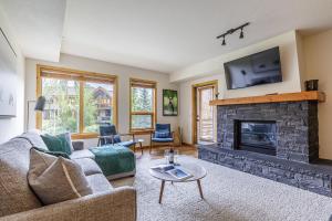 a living room with a couch and a fireplace at Tranquility at Rundle Cliffs Lodge in Canmore