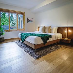 a bedroom with a large bed and a window at Tranquility at Rundle Cliffs Lodge in Canmore
