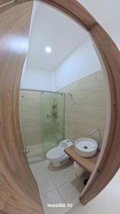 a bathroom with a sink and a toilet and a mirror at Amanecer Caribe 4503 in Coveñas