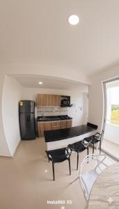 a kitchen with a table and chairs in a room at Amanecer Caribe 4503 in Coveñas
