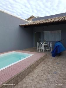 een huis met een zwembad en een tafel en stoelen bij Josy House in Cabo Frio