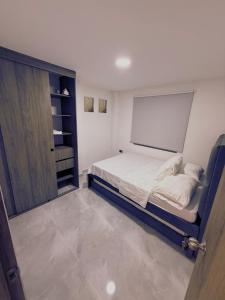 1 dormitorio pequeño con 1 cama y armario en Apartaestudio alucea, en Cali