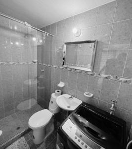 Un baño con inodoro, lavabo y espejo. en Apartaestudio alucea, en Cali