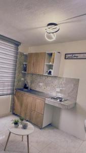 Una cocina con encimera y mesa en una habitación. en Apartaestudio alucea, en Cali