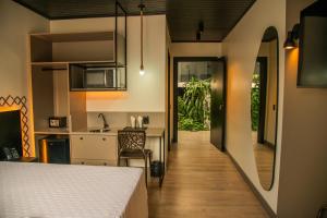 a room with a bed and a kitchen at Coroados Hotel & Flats in Nova Prata