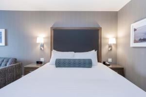 un grande letto bianco in una stanza d'albergo di Sandman Signature St. John's Hotel a St. John's